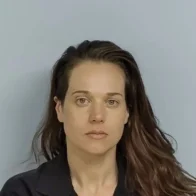 Woman accused of killing missing father found in shallow grave remains on the run, police say