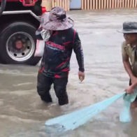 Man catches fish on flooded street in Thailand as death toll reaches 23