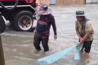 Man catches fish on flooded street in Thailand as death toll reaches 23