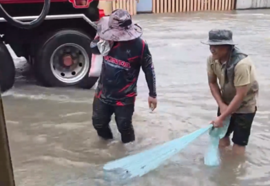 Man catches fish on flooded street in Thailand as death toll reaches 23