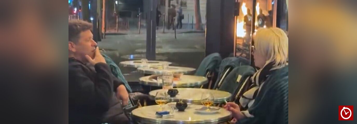 Couple sips cognac as protests rage in the background in Paris