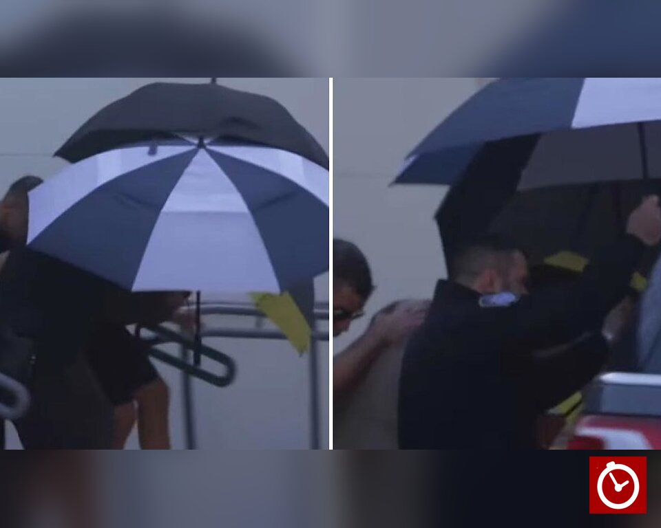 Flávio Bolsonaro arrives in Miami under umbrellas as security shields him from the press