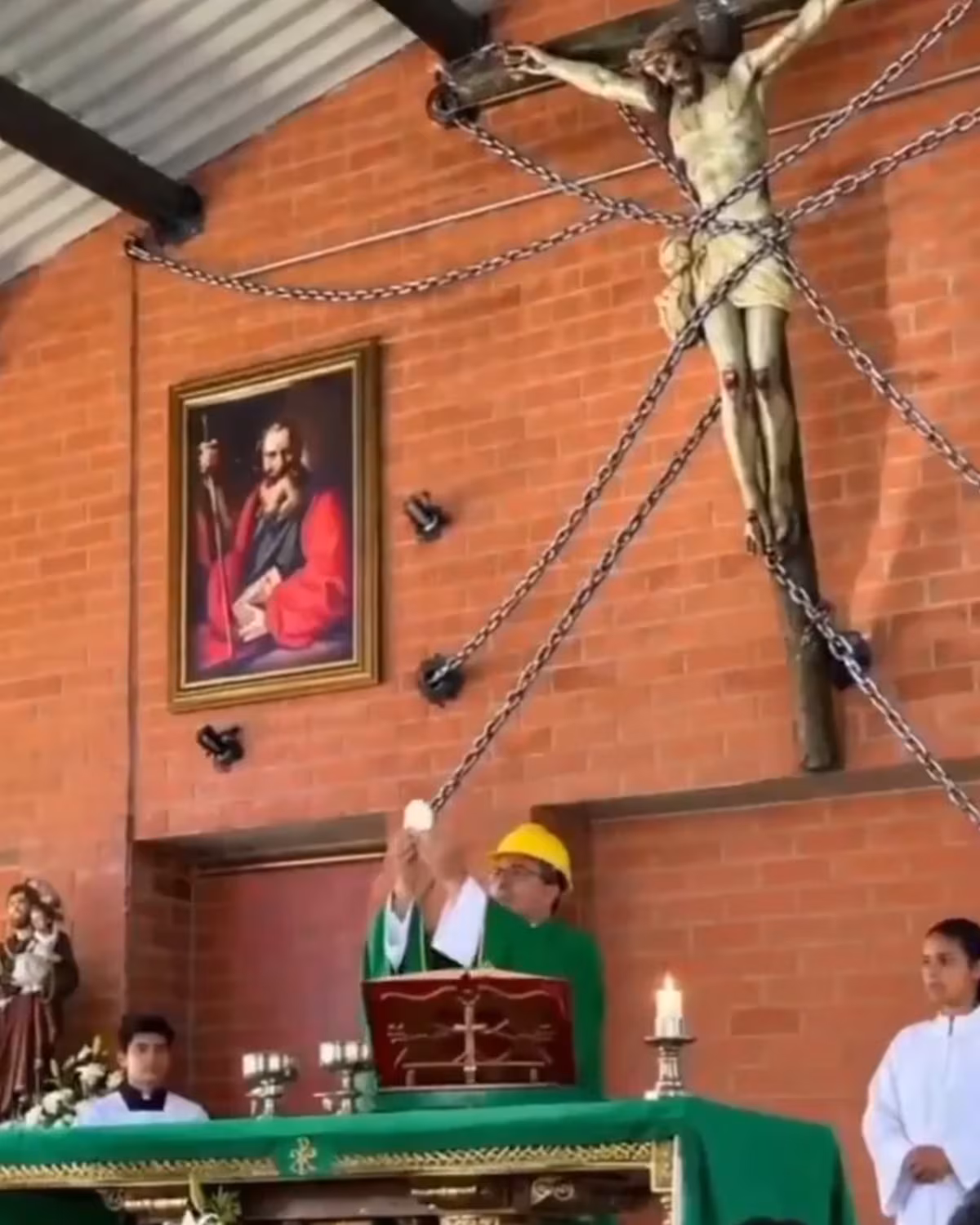 VIDEO: Priest wears construction helmet during Mass as chains secure statue of Christ