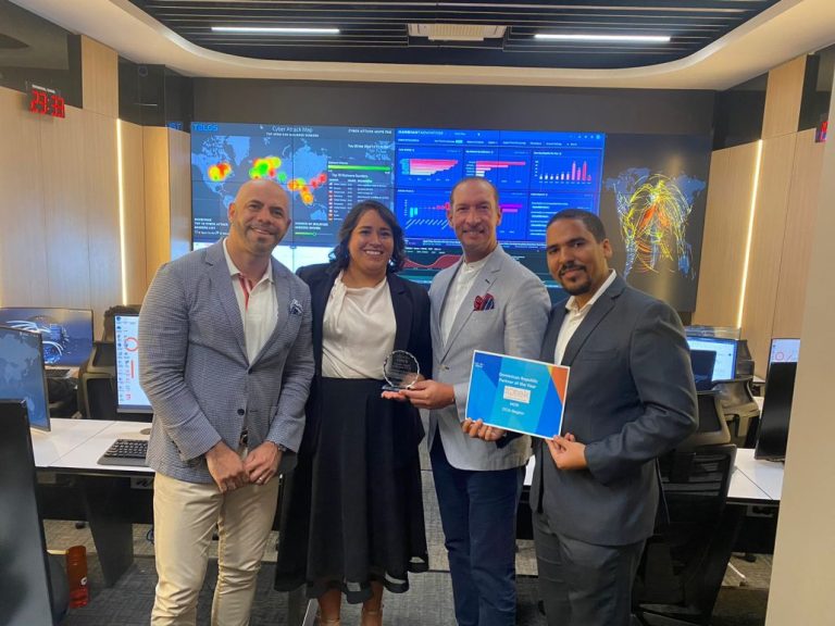 Ana Cristina Rojas, representante de Cisco, hace entrega del reconocimiento a los señores Junior Tolentino, Magín Ferreiro y Marucho Méndez.