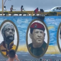 Venezolanos lanzan pintura negra a mural donde figura Hugo Chavez