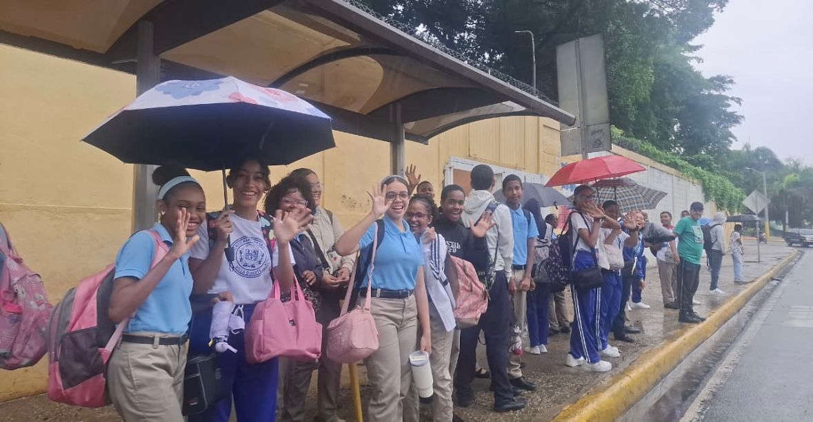 Estudiantes de Villa Duarte esperan transporte tras cierre de escuela por vaguada