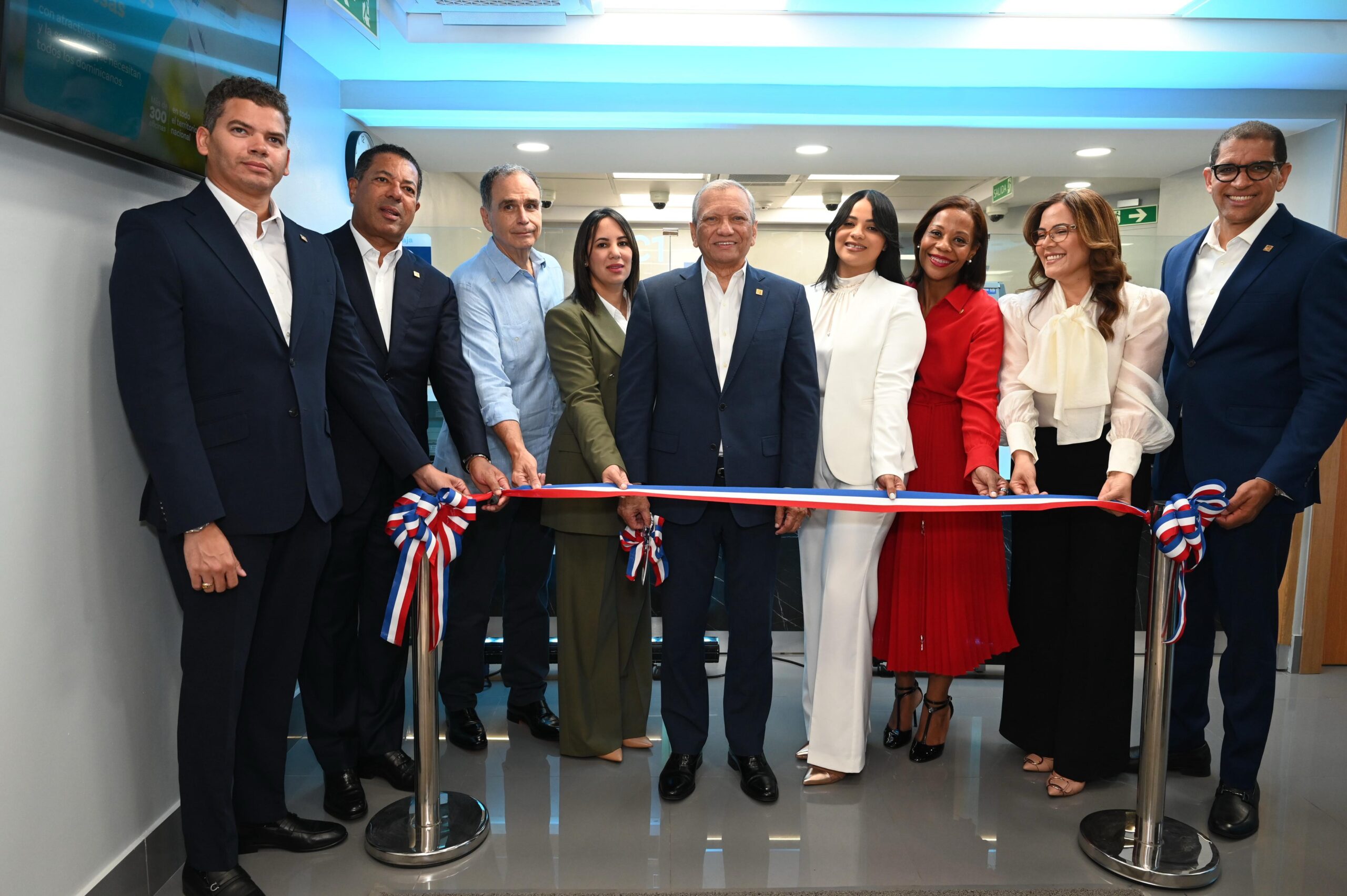 El presidente ejecutivo de Banreservas, Leonardo Aguilera, corta la cinta inaugural de una Unidad de Negocios Personales en Merca Jumbo Núñez de Cáceres. Le acompaña desde la izquierda el vicepresidente de Ingeniería, Manuel Guerrero; vicepresidente ejecutivo senior de Negocios, Ysidro García; el presidente del Grupo CCN, José Miguel González; la vicepresidente ejecutiva senior Administrativo, Alieska Díaz; la gerente de la oficina, Eridania Hernández; la directora de Negocios Corporativo zona metropolitana, Miguelina Medina; directora regional de Negocios zona metropolitana oeste, Lorenza Bencosme; y el vicepresidente ejecutivo de Negocios, Pablo de la Rosa.